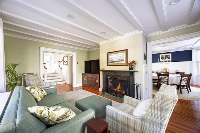 living room with a fireplace with flush hearth, stairs, ornamental molding, and wood finished floors