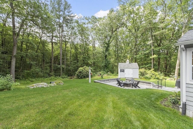 40 Abbott Ln, Chelmsford, MA 01824 - view of grassy yard with a fire pit, a patio, an outdoor structure, and a wooded view