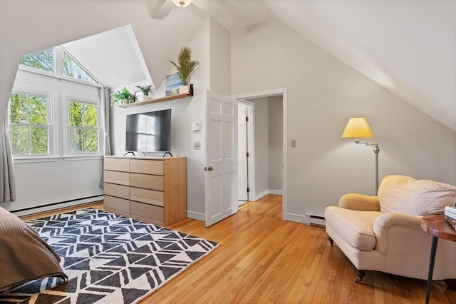 bedroom with baseboard heating, light wood-style floors, high vaulted ceiling, baseboards, and a baseboard heating unit