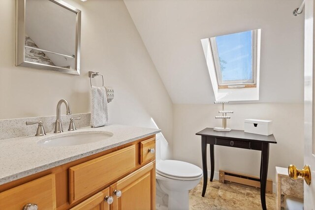 bathroom with vanity, baseboard heating, vaulted ceiling, and toilet