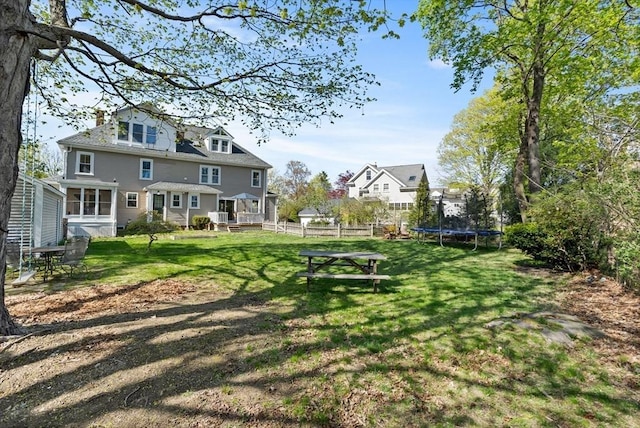 view of yard with a trampoline and fence