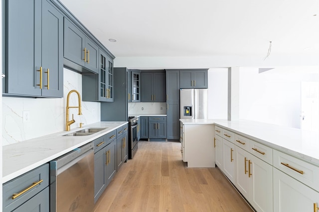 kitchen featuring white cabinets, decorative backsplash, stainless steel appliances, and light hardwood / wood-style floors