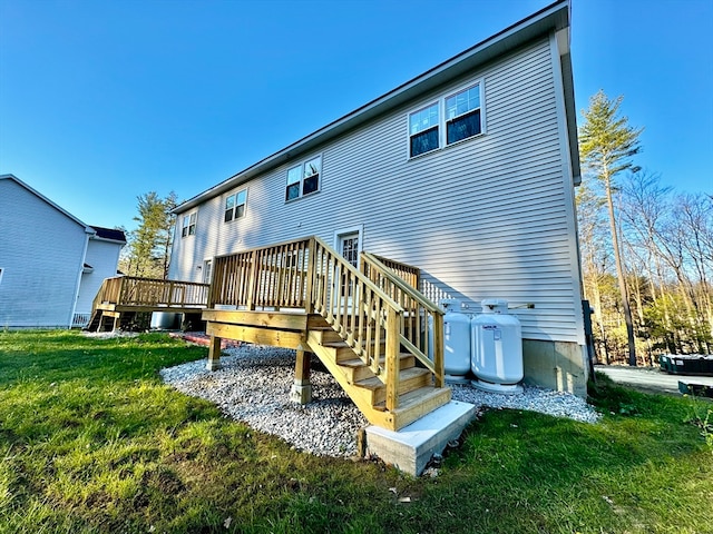 rear view of house featuring a wooden deck and a yard