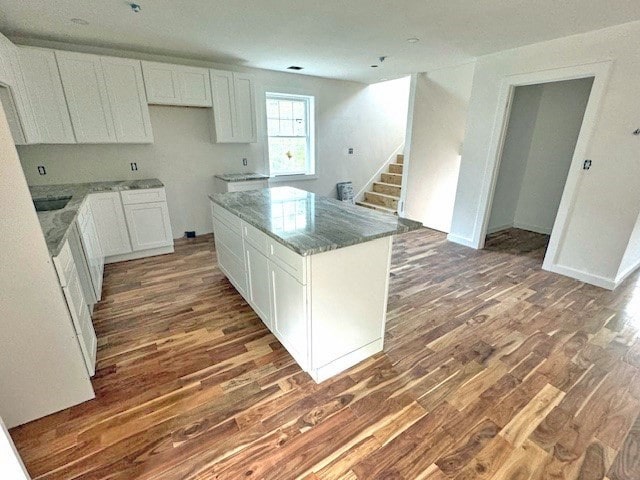 kitchen featuring white cabinetry, a center island, stone countertops, and dark hardwood / wood-style floors