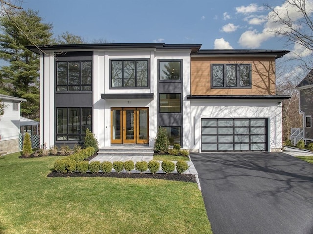 contemporary home with french doors, a front yard, and a garage