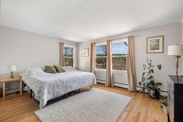 bedroom featuring a baseboard radiator and light wood finished floors