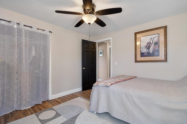 bedroom featuring baseboards, ceiling fan, and wood finished floors