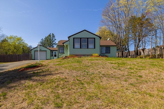 view of front of house with a garage, fence, a front lawn, and aphalt driveway