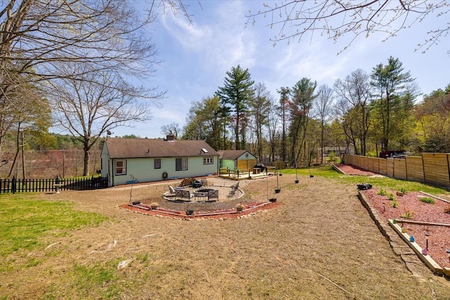 view of yard featuring fence, a fire pit, and a patio area