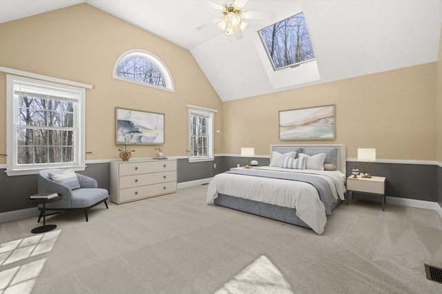 carpeted bedroom with baseboards, high vaulted ceiling, and a ceiling fan