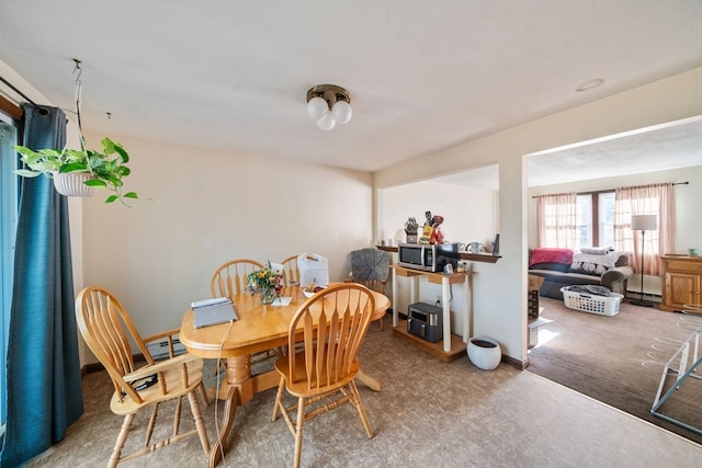 carpeted dining room with baseboard heating