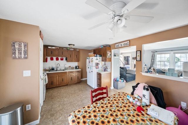 dining space featuring ceiling fan and sink