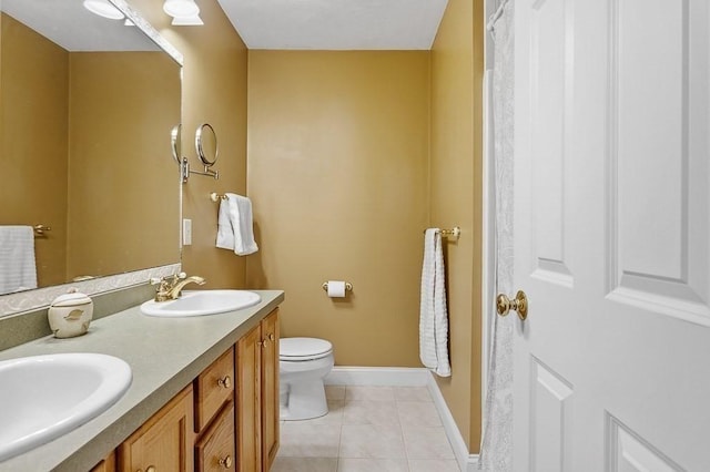 bathroom with toilet, vanity, and tile patterned flooring