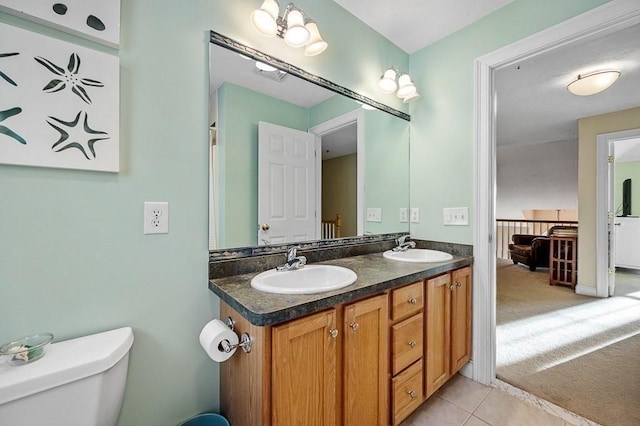 bathroom with toilet, vanity, a notable chandelier, and tile patterned floors