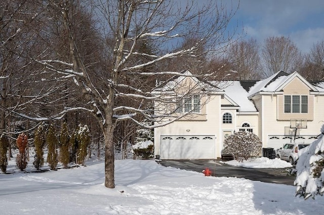 snow covered property featuring a garage