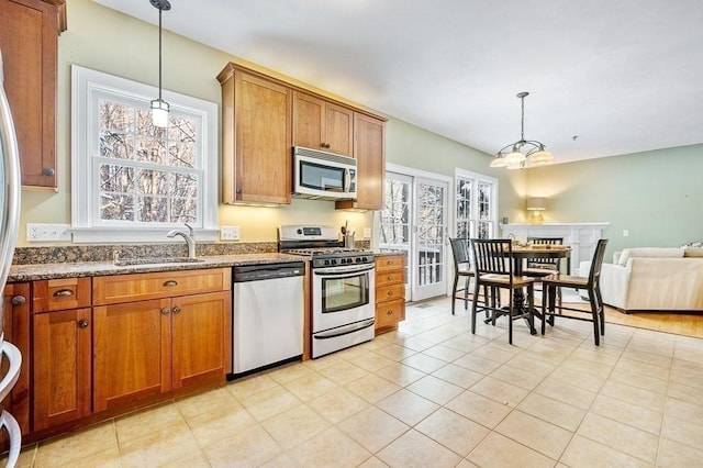 kitchen with stainless steel appliances, pendant lighting, plenty of natural light, and sink