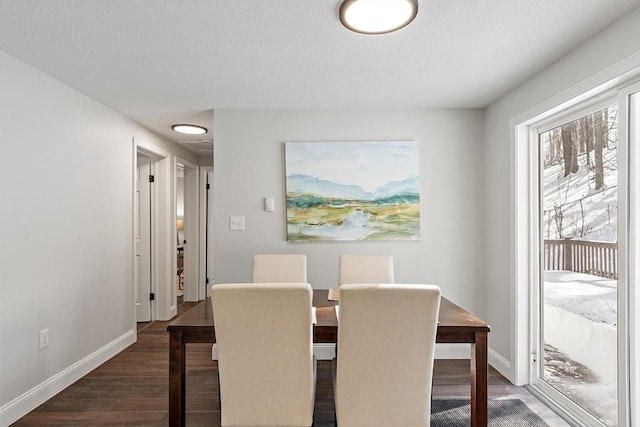 dining area featuring dark wood-style flooring and baseboards