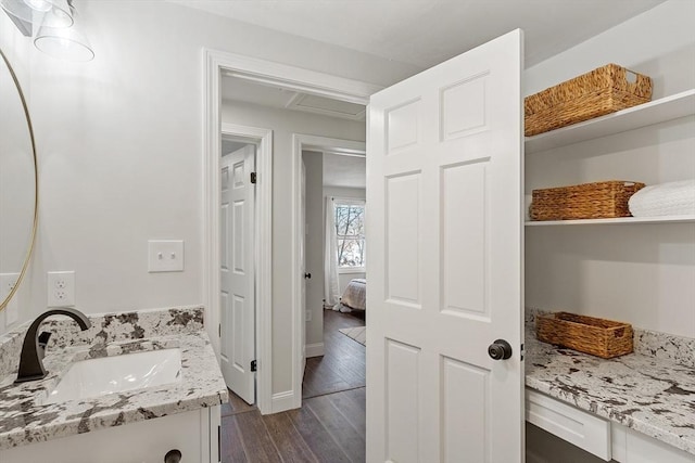 ensuite bathroom featuring baseboards, wood finished floors, vanity, and connected bathroom