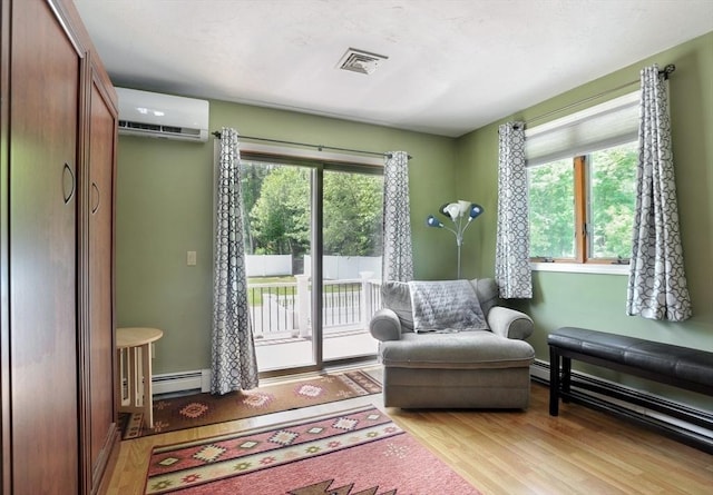 30 Pheasant Ln, Pembroke, MA 02359 - sitting room featuring a wall mounted air conditioner, a baseboard radiator, and light wood-type flooring