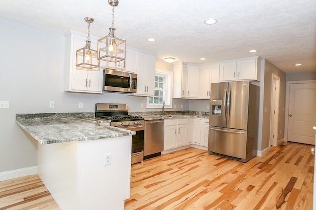 kitchen with white cabinets, light wood-type flooring, and stainless steel appliances