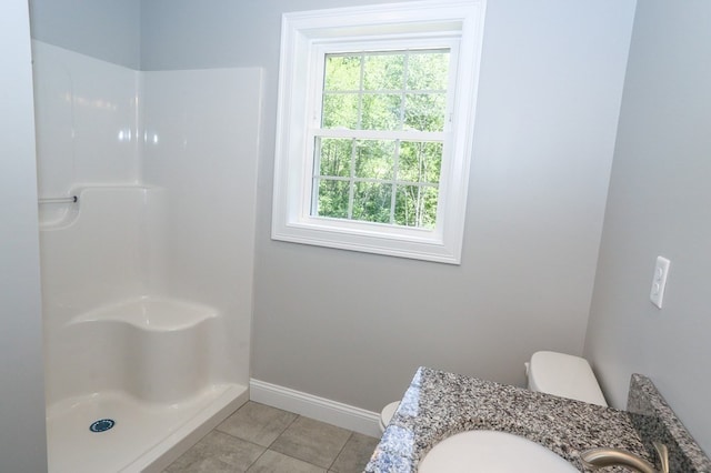 bathroom with walk in shower, a healthy amount of sunlight, toilet, and tile patterned flooring