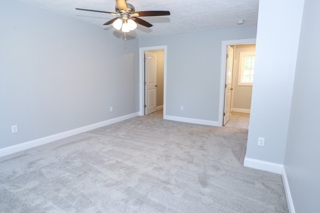 unfurnished bedroom featuring ceiling fan, a textured ceiling, and light carpet