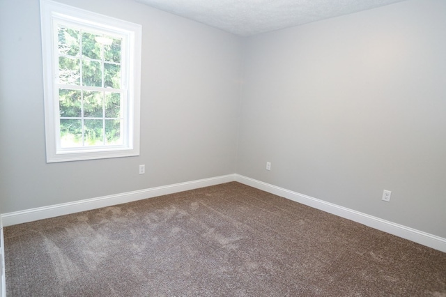 carpeted empty room with a textured ceiling