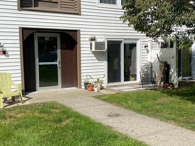 view of exterior entry with a yard