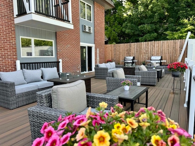 wooden terrace with outdoor lounge area and area for grilling