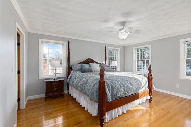 bedroom with multiple windows, baseboards, and wood finished floors