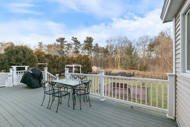 wooden terrace with outdoor dining space and a grill