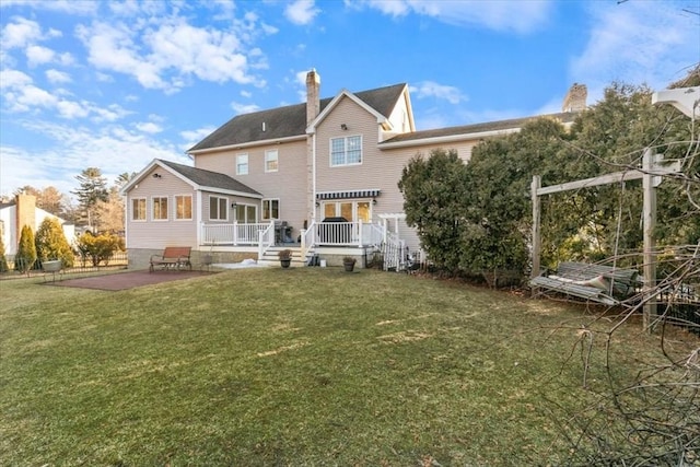 rear view of property featuring a patio and a yard