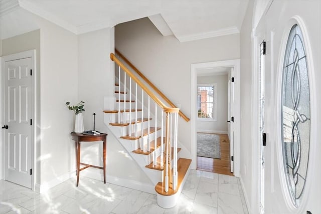 foyer with marble finish floor, baseboards, and ornamental molding