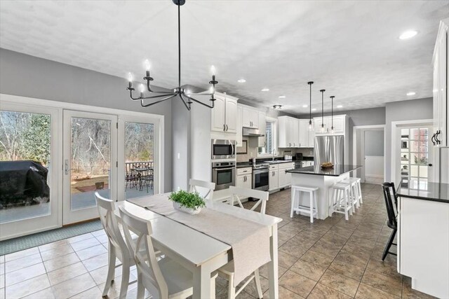 tiled dining area with a wealth of natural light, a notable chandelier, and recessed lighting