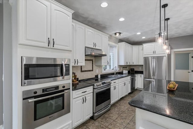 kitchen with under cabinet range hood, stainless steel appliances, white cabinetry, and a sink