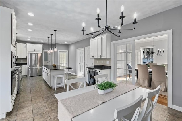 dining room with a chandelier, recessed lighting, tile patterned floors, and baseboards