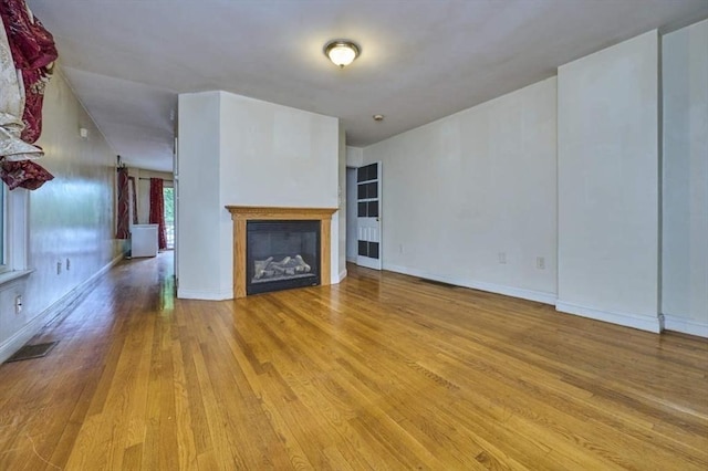 114 Mount Ida Rd Unit A, Boston, MA 02122 - unfurnished living room with wood finished floors, a glass covered fireplace, and baseboards