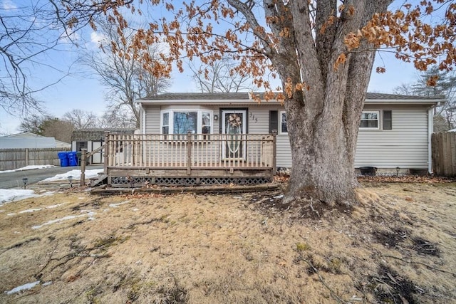 single story home featuring fence and a wooden deck