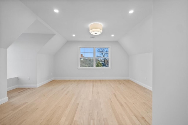 bonus room with lofted ceiling and light wood-type flooring