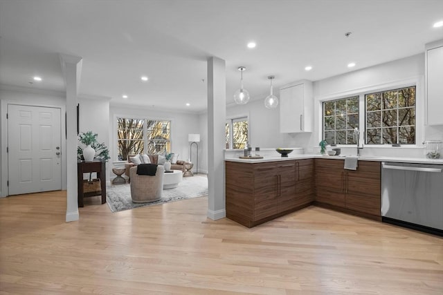 kitchen featuring sink, decorative light fixtures, light hardwood / wood-style flooring, stainless steel dishwasher, and white cabinets