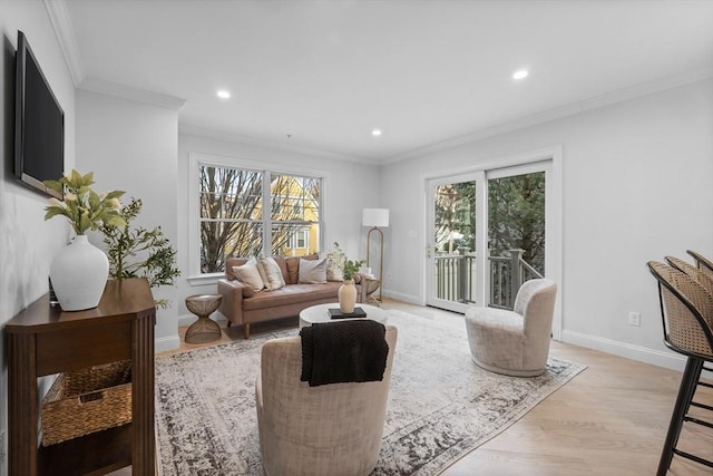 living room featuring crown molding, a healthy amount of sunlight, and light wood-type flooring