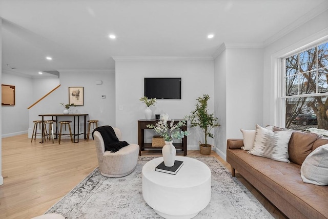 living room featuring ornamental molding and light hardwood / wood-style flooring