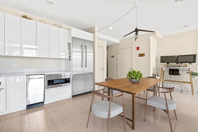 121 Portland St Unit Ph3, Boston, MA 02114 - kitchen with appliances with stainless steel finishes, light countertops, light wood-type flooring, white cabinetry, and recessed lighting
