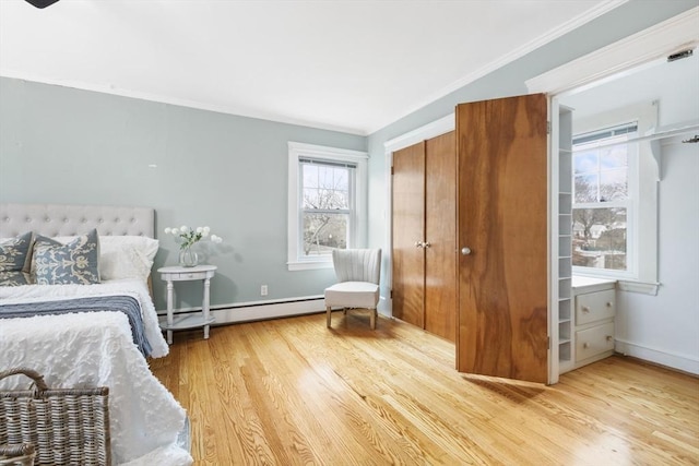 bedroom with light hardwood / wood-style flooring, baseboard heating, and ornamental molding