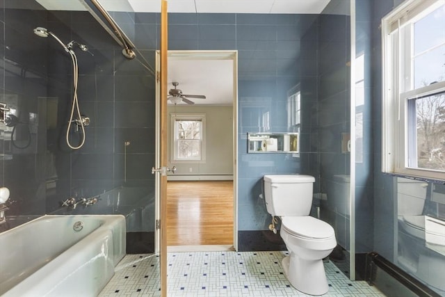 bathroom with ceiling fan, a baseboard radiator, tile walls, toilet, and tiled shower / bath