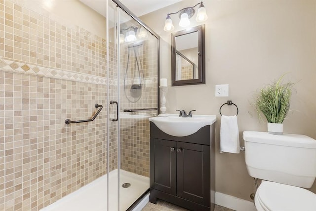 bathroom featuring vanity, toilet, and a shower with door