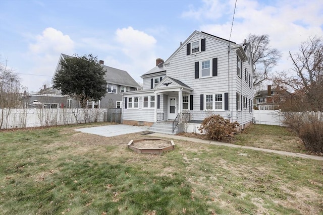 rear view of property featuring a lawn and a patio