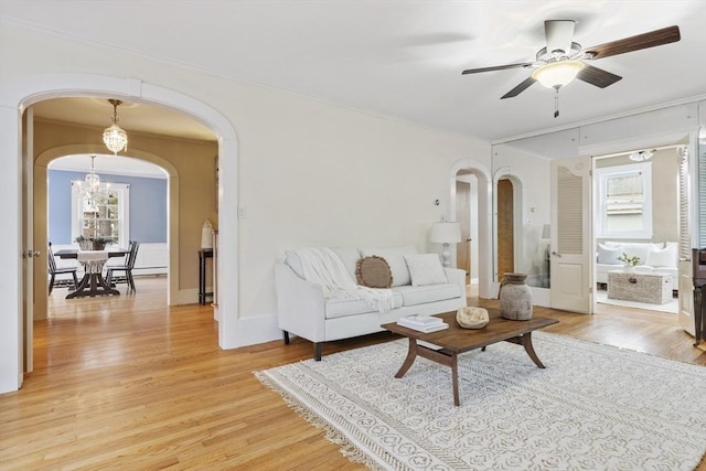 living room featuring light hardwood / wood-style flooring and ceiling fan with notable chandelier