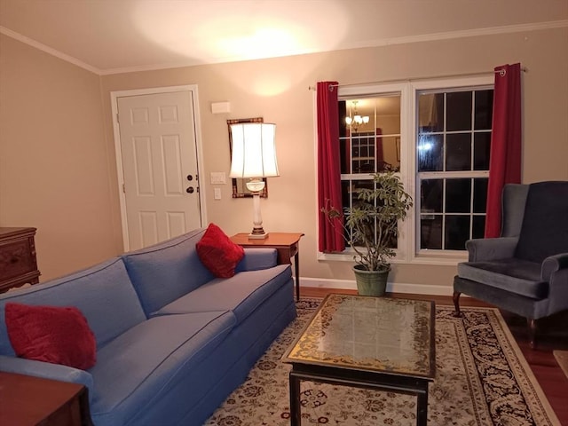 living area featuring ornamental molding, a notable chandelier, baseboards, and wood finished floors