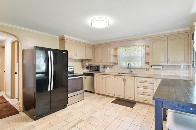kitchen with open shelves, light brown cabinetry, arched walkways, a sink, and stainless steel appliances
